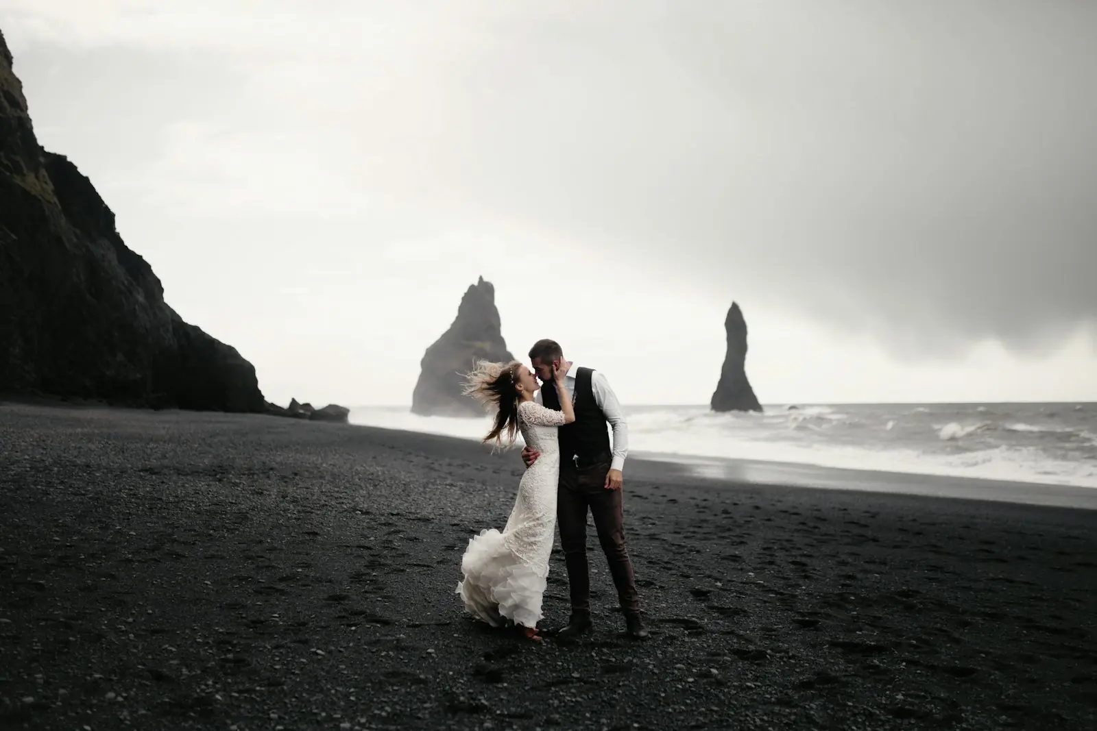 Couple kissing on a moody West Coast beach