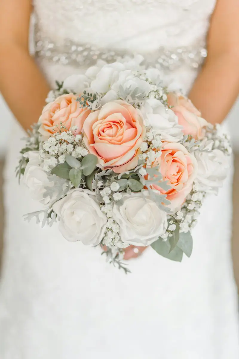 Bride holding a peach rose bouquet